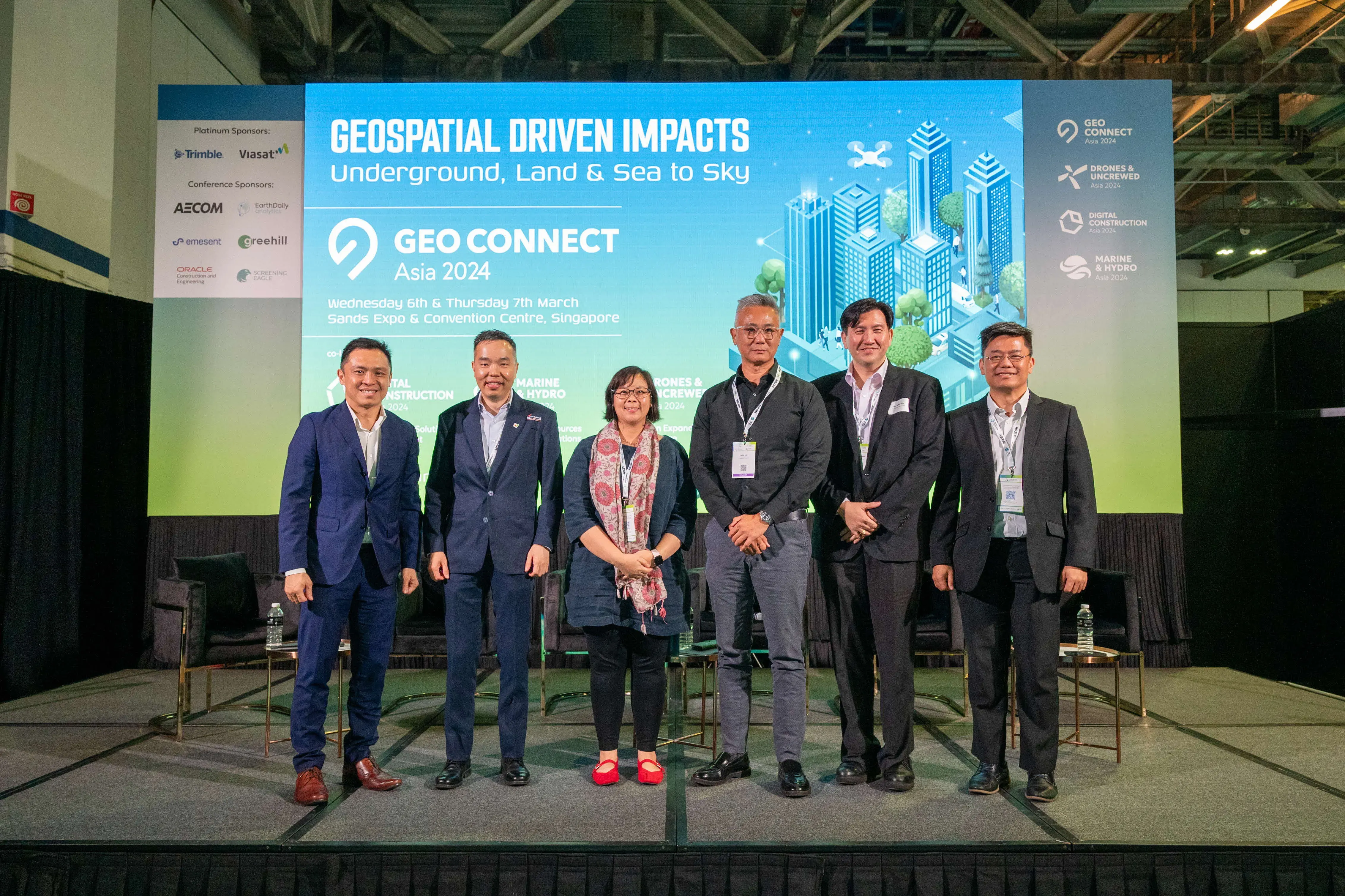 Six people stand on a stage in front of a Geo Connect Asia 2024 conference backdrop in Singapore.